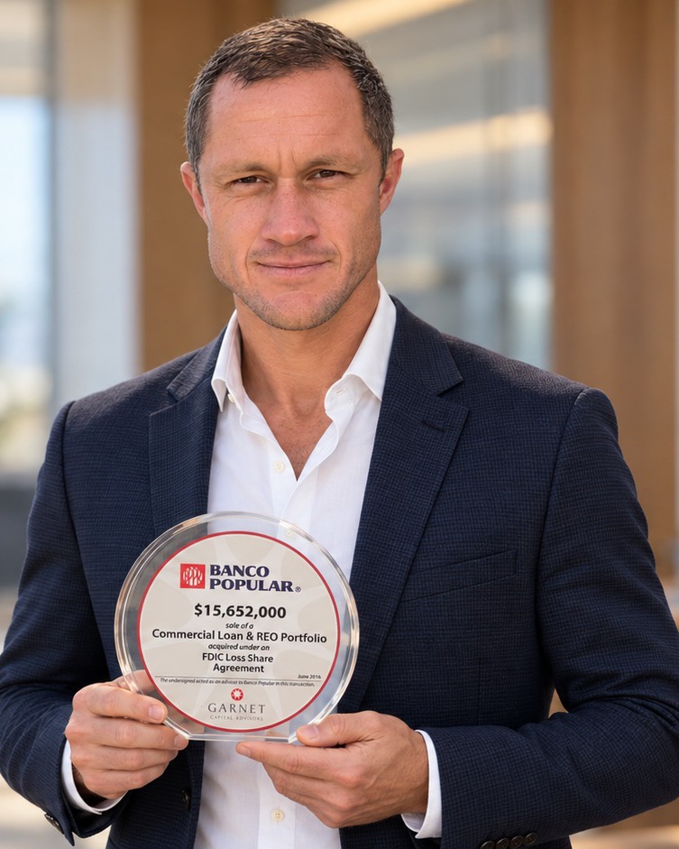 Joe Robert holding the deal plaque from Banco Popular de Puerto Rico’s 2016 portfolio sale